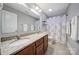 Bright bathroom with a double sink vanity, granite countertops, and shower with patterned curtain at 1122 Hartmann Ct, Fort Mill, SC 29715