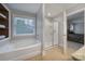 Bathroom with a large tub, walk-in shower, tile floor and natural lighting at 1122 Hartmann Ct, Fort Mill, SC 29715