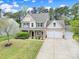 Charming two-story home with neutral siding, stone accents, manicured lawn, and a three car garage at 1122 Hartmann Ct, Fort Mill, SC 29715