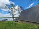 Exterior view showcasing the home's stone foundation and lush green lawn leading to the waterfront at 120 Ole Point Ln, Salisbury, NC 28146