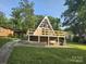 A-frame house with a spacious deck and a swing, surrounded by lush greenery at 120 Ole Point Ln, Salisbury, NC 28146