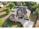 Aerial view of a brick home featuring mature landscaping, a circular driveway, and turret at 121 Dabbling Duck Cir, Mooresville, NC 28117