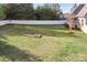 Spacious backyard featuring a grass lawn, an in-ground fire pit, and white fence at 121 Dabbling Duck Cir, Mooresville, NC 28117