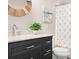 Modern bathroom features a dark vanity with marble top, patterned shower curtain, and round wood mirror at 121 Dabbling Duck Cir, Mooresville, NC 28117