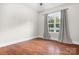 Bright bedroom with wood floors, large window, and neutral walls create a serene atmosphere at 121 Dabbling Duck Cir, Mooresville, NC 28117