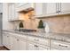 Charming kitchen features granite countertops, stone backsplash, and white cabinets at 121 Dabbling Duck Cir, Mooresville, NC 28117
