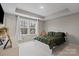 A nicely decorated bedroom featuring a trey ceiling, white trim, and large window for plenty of light at 12312 Landry Renee Pl # 35, Charlotte, NC 28277
