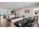 Open dining area with dark wood table, white island, and access to living area and powder room at 12312 Landry Renee Pl # 35, Charlotte, NC 28277