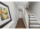 Bright hallway featuring hardwood floors, a staircase, and a modern piece of art at 12312 Landry Renee Pl # 35, Charlotte, NC 28277
