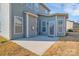 A concrete patio featuring a door to the home and a small patch of dying grass at 12724 Hunting Birds Ln, Charlotte, NC 28278