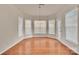 Bright dining area with wood floors, bay windows, and a modern pendant light fixture at 12724 Hunting Birds Ln, Charlotte, NC 28278