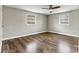 An empty bedroom with hardwood floors, ceiling fan, and two windows with blinds at 1407 17Th Ne Ave, Hickory, NC 28601