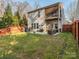 Expansive backyard featuring a patio with comfortable seating, lush green lawn, and privacy fence at 1708 Royal Gorge Ave, Charlotte, NC 28210