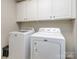 Bright laundry area has a washer, dryer, and cabinet storage at 1708 Royal Gorge Ave, Charlotte, NC 28210