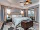 Cozy main bedroom features a tufted headboard, a ceiling fan, and lots of natural light at 1708 Royal Gorge Ave, Charlotte, NC 28210