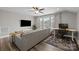 Comfortable living area features a plush gray sectional sofa, desk space, and large window at 1710 Woodward Ave, Charlotte, NC 28206