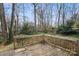 View of wooden deck in backyard surrounded by lush greenery and trees at 1715 Shagbark Ln, Charlotte, NC 28226