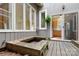 Wooden back patio area with built-in benches and views into kitchen and upper floor windows at 1715 Shagbark Ln, Charlotte, NC 28226