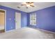A charming bedroom featuring a window, ceiling fan, and painted blue walls at 1715 Shagbark Ln, Charlotte, NC 28226