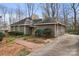Side view of home with brick walkway, mature landscaping, and long concrete driveway at 1715 Shagbark Ln, Charlotte, NC 28226