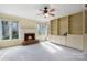 Inviting living room with a brick fireplace, a ceiling fan, and built-in shelving at 1715 Shagbark Ln, Charlotte, NC 28226