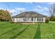 Rear exterior featuring ample windows, a door to the backyard, and a manicured lawn at 2019 W Laporte Dr, Charlotte, NC 28216