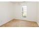 Empty bedroom features neutral carpet, light walls and a window at 2019 W Laporte Dr, Charlotte, NC 28216