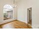 Dining room features a large arched window, hardwood floors and a decorative chandelier at 2019 W Laporte Dr, Charlotte, NC 28216