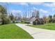 Exterior view with a long driveway, shed, and garage, showcasing a well-kept lawn at 2019 W Laporte Dr, Charlotte, NC 28216