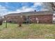 Brick home featuring a wooden deck and a spacious grassy backyard with a mix of patchy and healthy grass at 218 Countryside Rd, Kings Mountain, NC 28086