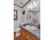 Well-lit bathroom featuring a single vanity, toilet, shower with glass doors, and a decorative mirror at 218 Countryside Rd, Kings Mountain, NC 28086