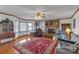 Bright living room showcasing a stone fireplace, ceiling fan, hardwood floors, and an area rug at 218 Countryside Rd, Kings Mountain, NC 28086