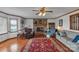 Cozy living room featuring a stone fireplace, hardwood floors, ceiling fan and comfortable seating at 218 Countryside Rd, Kings Mountain, NC 28086