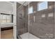 Beautiful bathroom with glass enclosed shower, grey stone tile and natural light at 233 Catawba Crest Ln, Clover, SC 29710