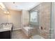 Bright bathroom featuring a walk-in shower, soaking tub, and double sink vanity at 3002 Paddington Dr, Indian Trail, NC 28079