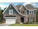 This two-story home boasts a blend of stone and siding, complemented by a two-car garage at 3034 Tramore Dr, Harrisburg, NC 28075