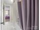 Well-lit bathroom features a shower-tub combo with neutral tile and mauve shower curtain at 3549 Sandy E Trl, Fort Mill, SC 29707