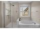Bright bathroom featuring a walk-in shower, soaking tub, and a window with natural light at 3549 Sandy E Trl, Fort Mill, SC 29707