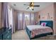 Cozy bedroom with a blue frame bed, ceiling fan, and large windows with lilac curtains at 3549 Sandy E Trl, Fort Mill, SC 29707