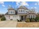 Charming two-story home boasts a two-car garage, stone accents and manicured landscaping at 3549 Sandy E Trl, Fort Mill, SC 29707