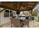 Relaxing patio with a wooden pergola, ceiling fan, and outdoor television set over a wicker table with place settings at 3549 Sandy E Trl, Fort Mill, SC 29707