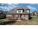 A backyard features a brick house with a wooden deck, grass, and a stone patio at 3815 10Th Ne St, Hickory, NC 28601