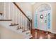 Bright foyer featuring hardwood floors, a staircase, and front door with decorative glass at 3815 10Th Ne St, Hickory, NC 28601