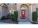 Close up of a red front door with arched window, surrounded by brick and manicured bushes at 3815 10Th Ne St, Hickory, NC 28601