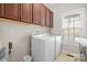Well-lit laundry room featuring a white washer and dryer, cabinets, and tile flooring at 3815 10Th Ne St, Hickory, NC 28601