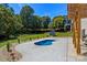 Serene backyard featuring a small pool, lush landscaping, and a storage shed at 4808 1St Nw St, Hickory, NC 28601