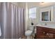 Well-lit bathroom featuring a shower with tub and a cherry wood vanity and sink at 5703 Eleanor Rigby Rd, Charlotte, NC 28278