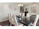 Elegant dining room with large table and chairs set on hardwood floors, with views of the stairwell at 5703 Eleanor Rigby Rd, Charlotte, NC 28278