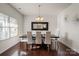 Bright dining room with large dark wood table, white chairs and hardwood floors at 5703 Eleanor Rigby Rd, Charlotte, NC 28278