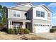 Two-story home with gray siding, white trim, manicured bushes, and a two-car garage at 5703 Eleanor Rigby Rd, Charlotte, NC 28278